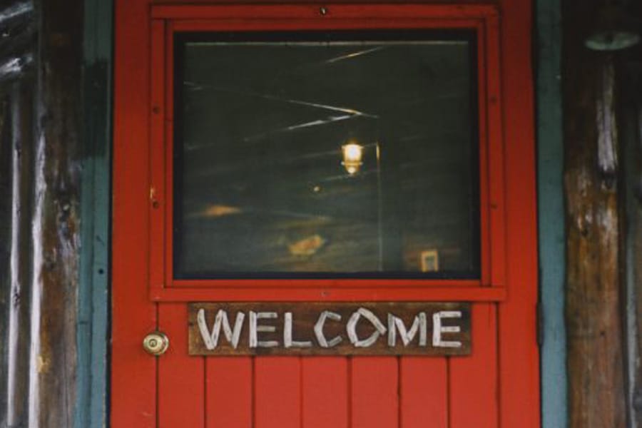 Welcome sign at an art gallery entrance with a vibrant background